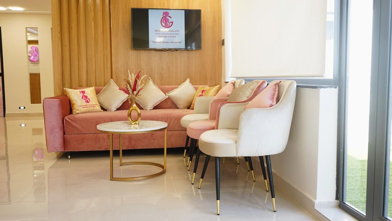 Salle d'attente élégante avec canapé rose et fauteuils