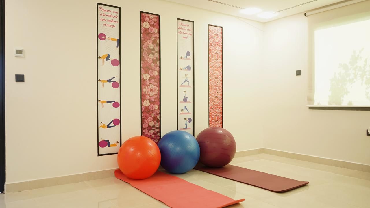 Salle de préparation à l'accouchement avec ballons et tapis de yoga
